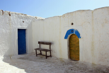A close-up view of the entrance door to a traditional Bedouin house, featuring rustic materials and...