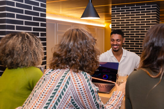 Team collaborating around a laptop in modern workspace