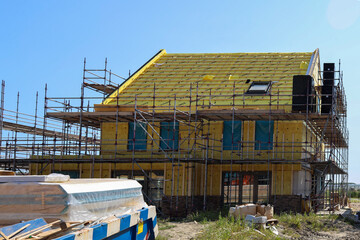 House full of insulation during construction with scaffolding