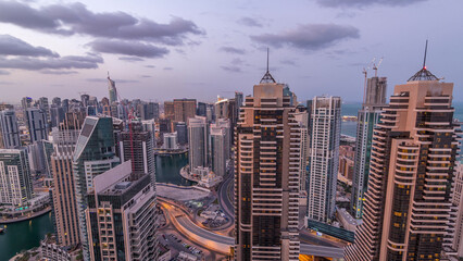 Dubai Marina skyscrapers and jumeirah lake towers view from the top aerial night to day timelapse...
