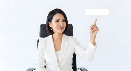 A professional woman sitting and pointing upward as if indicating a call to action button, on white
