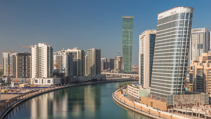 Fototapeta premium Skyscrapers near canal in Dubai with blue sky aerial timelapse