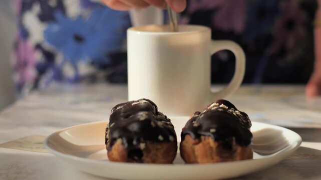 Eclairs coffee dessert - Delicious chocolate eclairs on a plate with a coffee cup, perfect for a sweet dessert or break.