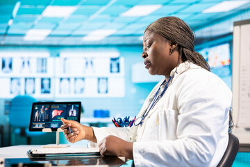 Black physician providing checkup examination on insurance with patient, employing technology for...