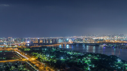 Fototapeta premium Nighttime rhythm of the city of Dubai near canal aerial timelapse