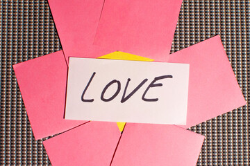 Paper written love with other papers next to it.