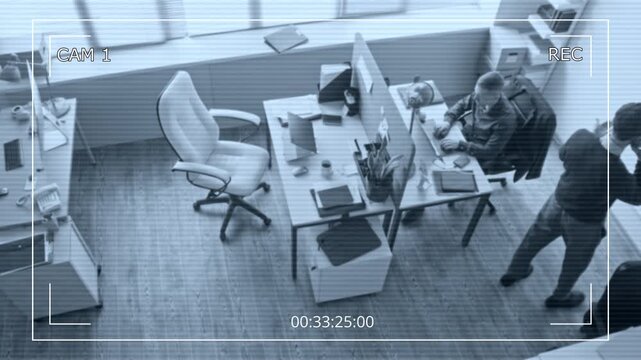 Security camera footage of male manager walking around office room equipped with partitioned desk talking on smartphone then passing phone to colleague during business planning conversation - Powered by Adobe