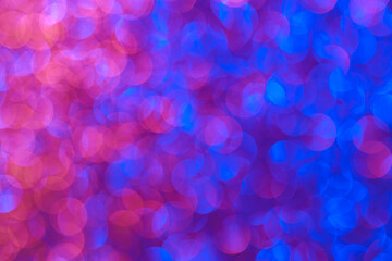 The image is a blurry, colorful background with blue and pink tones