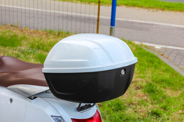 Modern black and white spherical street lamp mounted on pole against green grass and urban...
