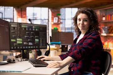 Portrait of smiling woman working in AI tech agency providing custom software development services. Upbeat IT staff member using machine learning to streamline coding process in startup office