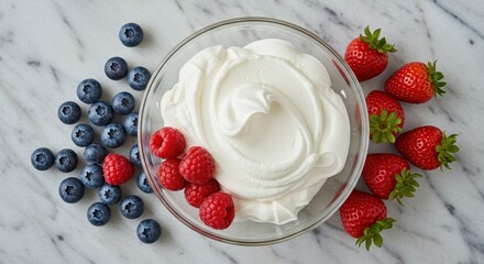 Fresh Cream with Berries in a Bowl on Marble Surface with Raspberries, Blueberries, and Strawberries Decoratively Arranged