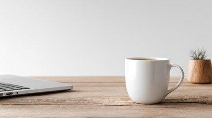 Sleek Laptop and Coffee Cup on a Sparse Wooden Desk with a Pristine White Backdrop