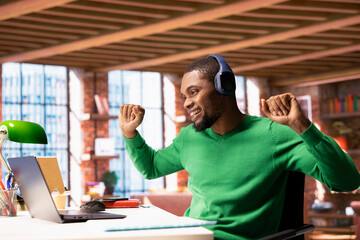 Cheerful man in modern apartment listening music during leisure time, feeling pleased. Jolly...