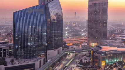 Dubai downtown street with busy traffic and skyscrapers around night to day timelapse.