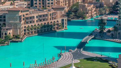 Top close up view of the bridge over man-made lake and some people walking in park