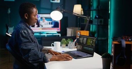 Video editor selecting key frames to use while doing video montage, working from home on notebook...