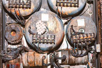 Electrical panel damaged after a fire with charred wires and melted components indicating intense...
