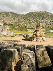 Ancient ruins in a mountainous landscape featuring carved stone structures