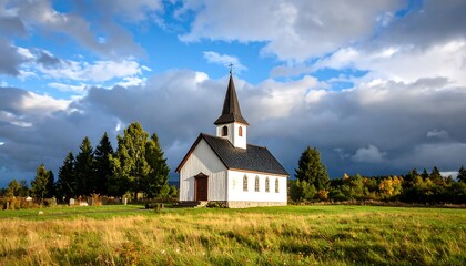 Obraz premium Tranquil church in a grassy field under dramatic skies