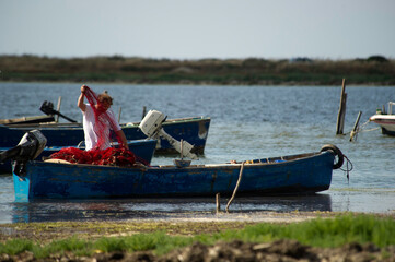 fishing boats, fishermen and fishing traps in the port at Marceddì, Oristano, Sardinia, Italy