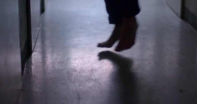 In this captivating video, observe a person walking barefoot down a serene hallway, their footsteps echoing softly, creating a calm atmosphere