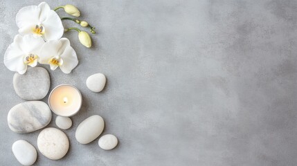 Relaxation layout with orchids, stones, and a candle on a gray background