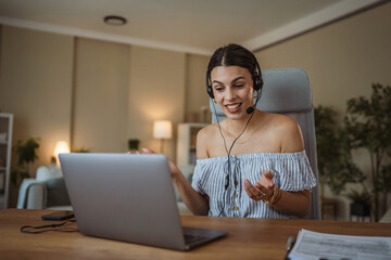 adult woman with headset have web conference while working from home