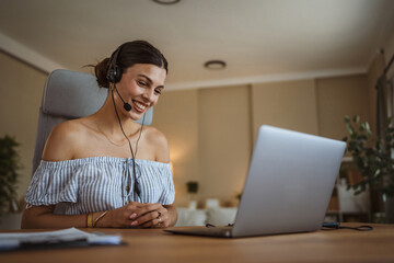 adult woman with headset have web conference while working from home