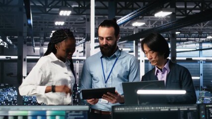 Portrait of smiling engineers in server room using AI to review infrastructure diagnostics. Cheerful IT coworkers in data center analyzing performance data using artificial intelligence, camera A - Powered by Adobe
