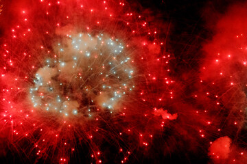 Red and blue fireworks explosion in night sky. Abstract festive background with glowing sparks,...