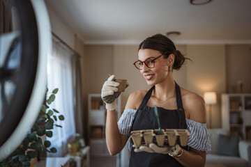 woman gardener blogger show eco seedlings recording video at home