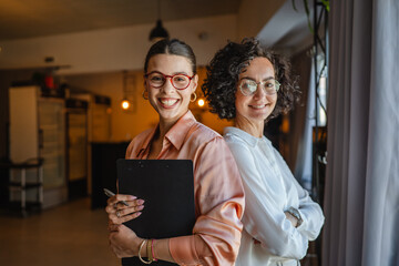 Portrait of two businesswoman elegant wear stand back on back
