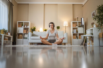 peaceful woman doing guided meditation yoga self care practice at home