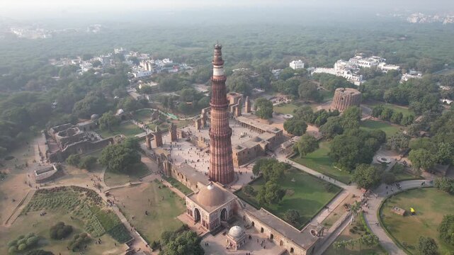 Aerial Drone footage of  Qutub Minar a Unesco world heritage site in New Delhi  capital city  of India  monuments of Delhi  during the day .