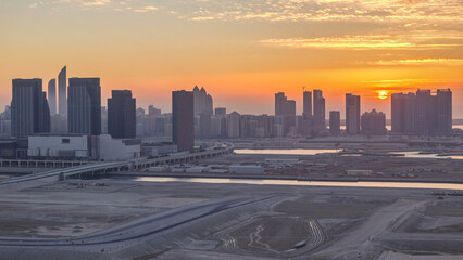 Buildings on Al Reem island in Abu Dhabi at sunset timelapse from above.