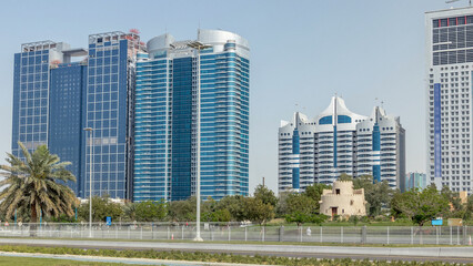 Corniche boulevard beach park along the coastline in Abu Dhabi timelapse with skyscrapers on...