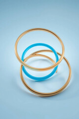 Fototapeta premium Three colorful bangles stacked on a light blue background