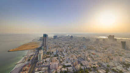 Sunrise with cityscape of Ajman from rooftop aerial timelapse.
