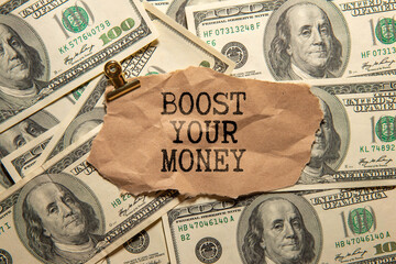 A notebook with the words Boost your Money written on it. a calculator