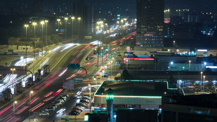 Traffic on a big road junction in Ajman aerial view from rooftop at night timelapse.
