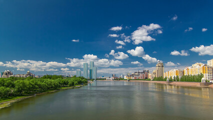 Naklejka premium Yesil river timelapse hyperlapse with modern towers of residential complex in Astana