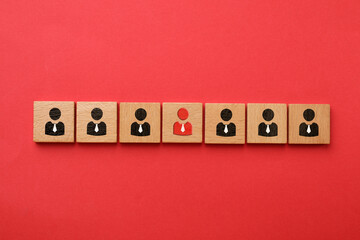 Dismissal. Cube with red human icon among others with black ones on red background, top view