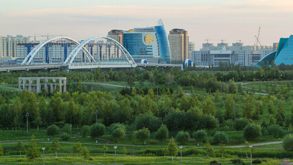 Panorama of the Astana city before sunset timelapse with bridge and buildings. View over the park