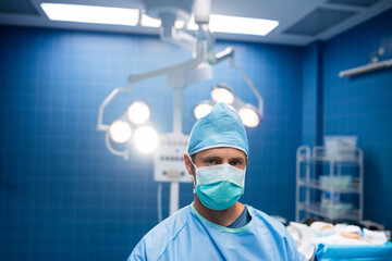 Overhead surgical lights shining brightly in operating room with steel trolley holding instruments