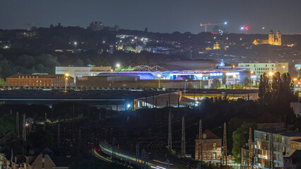 Aerial night timelapse of Brussels North station railway tracks with trains arriving and departing. Belgium