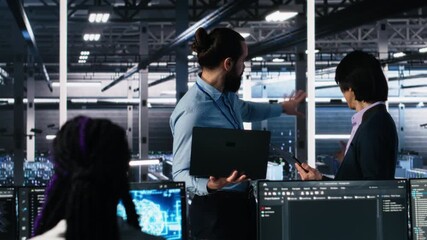 Data center manager supervising work done by programmers working on neural network software. Server hub supervisor overseeing IT staff members implementing deep learning tech, camera A - Powered by Adobe