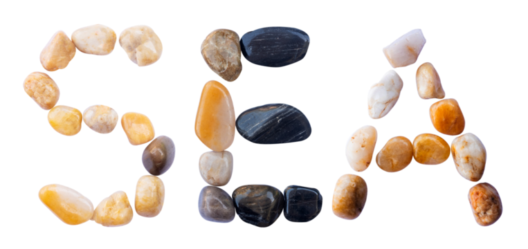 SEA word is made of stone with a white background. The creative shapes of the letters of the alphabet are arranged with stones.
