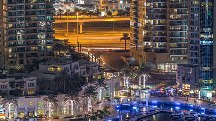 Luxury Dubai Marina canal with passing boats and promenade night timelapse, Dubai, United Arab Emirates