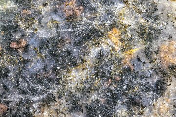 Detailed close-up of a mineral-rich rock cut, ideal as a natural texture background with earthy tones and sparkling particles.