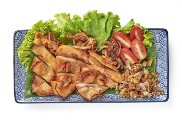 Deep fried sun dried squid served with fresh lettuce, cherry tomatoes, and crispy fried garlic on decorative plate, offering delicious and savory seafood dish